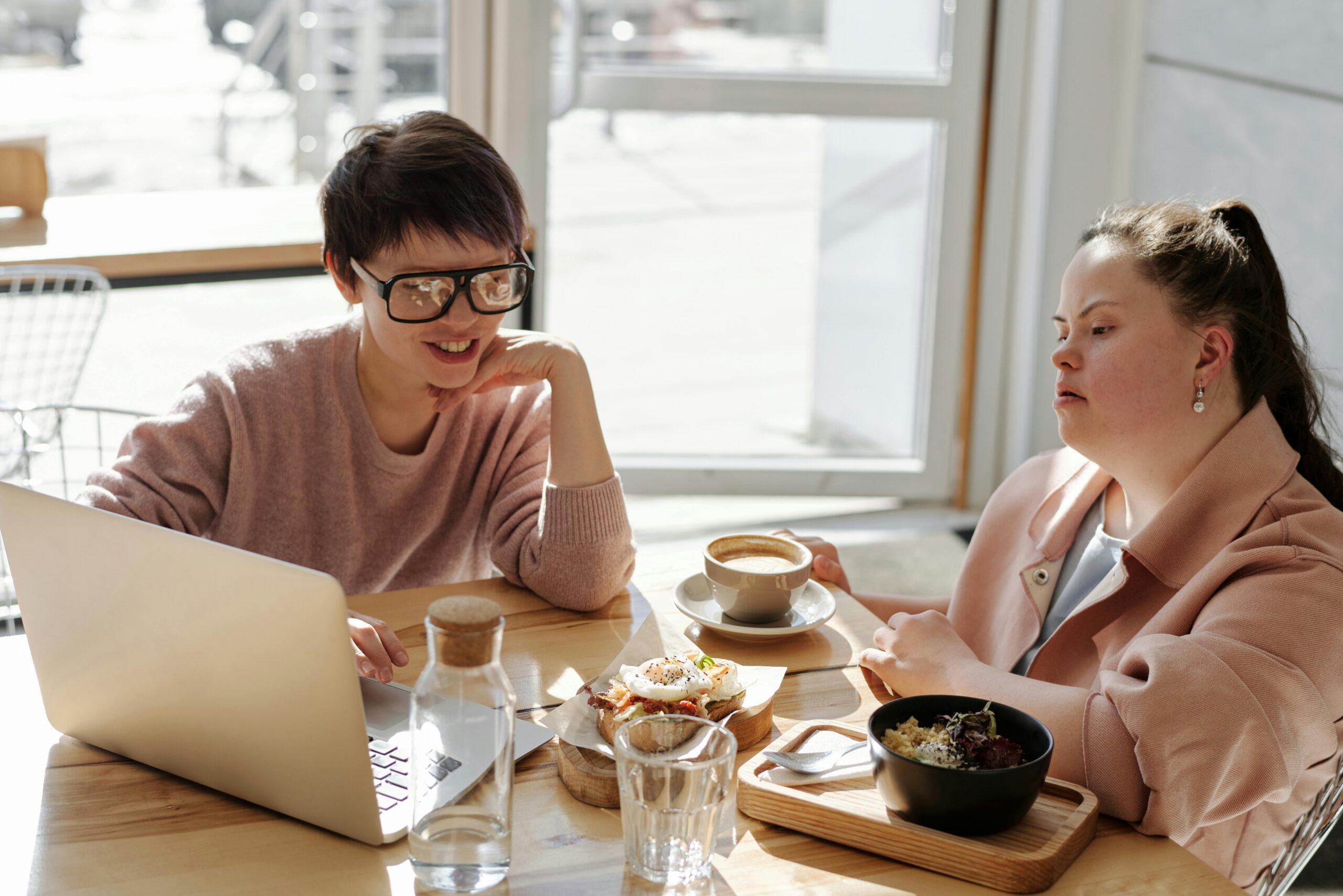 Two people sat at a desk working on a computer