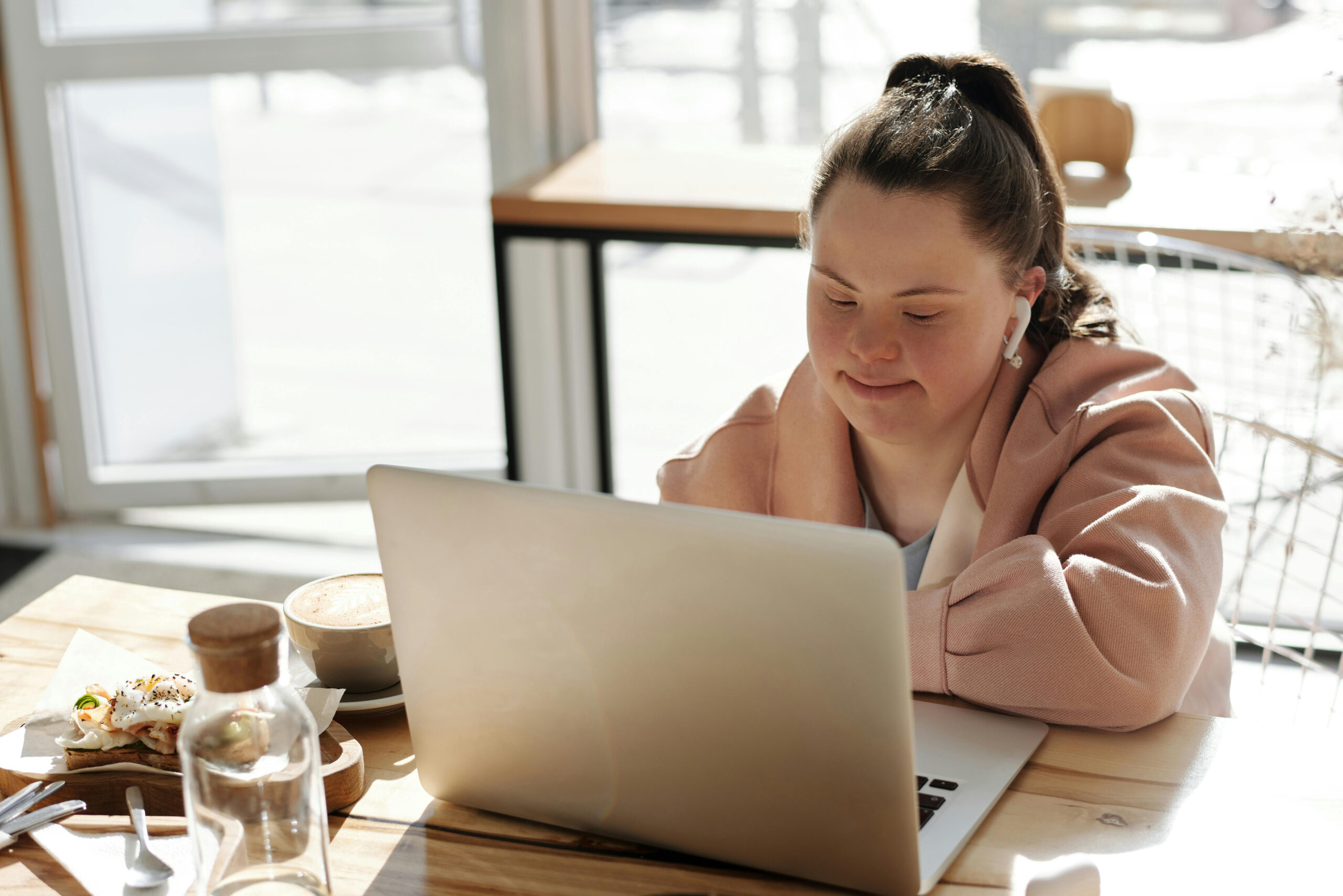 A woman sat at a desk working on a laptop