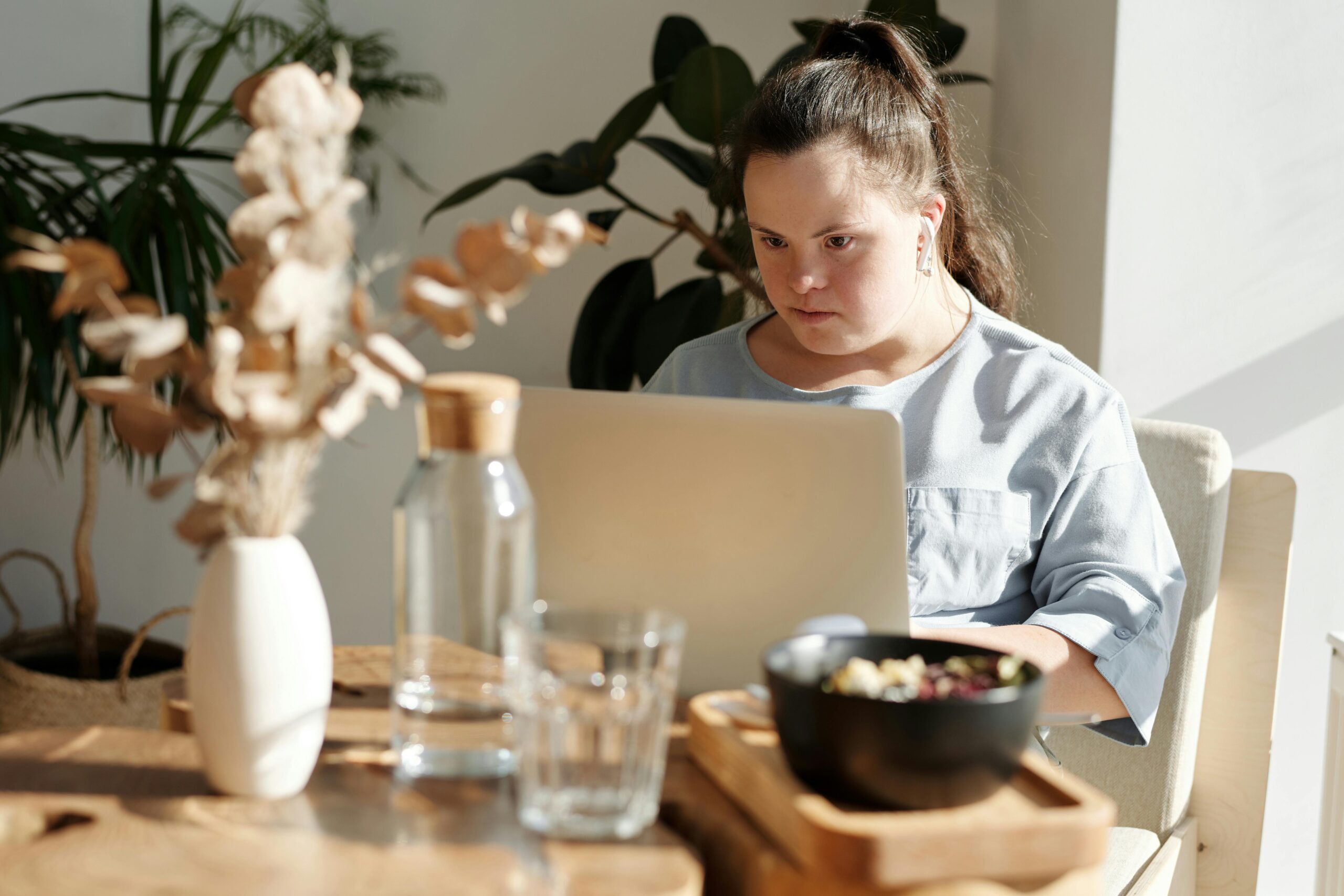 A woman using her laptop sat to a table